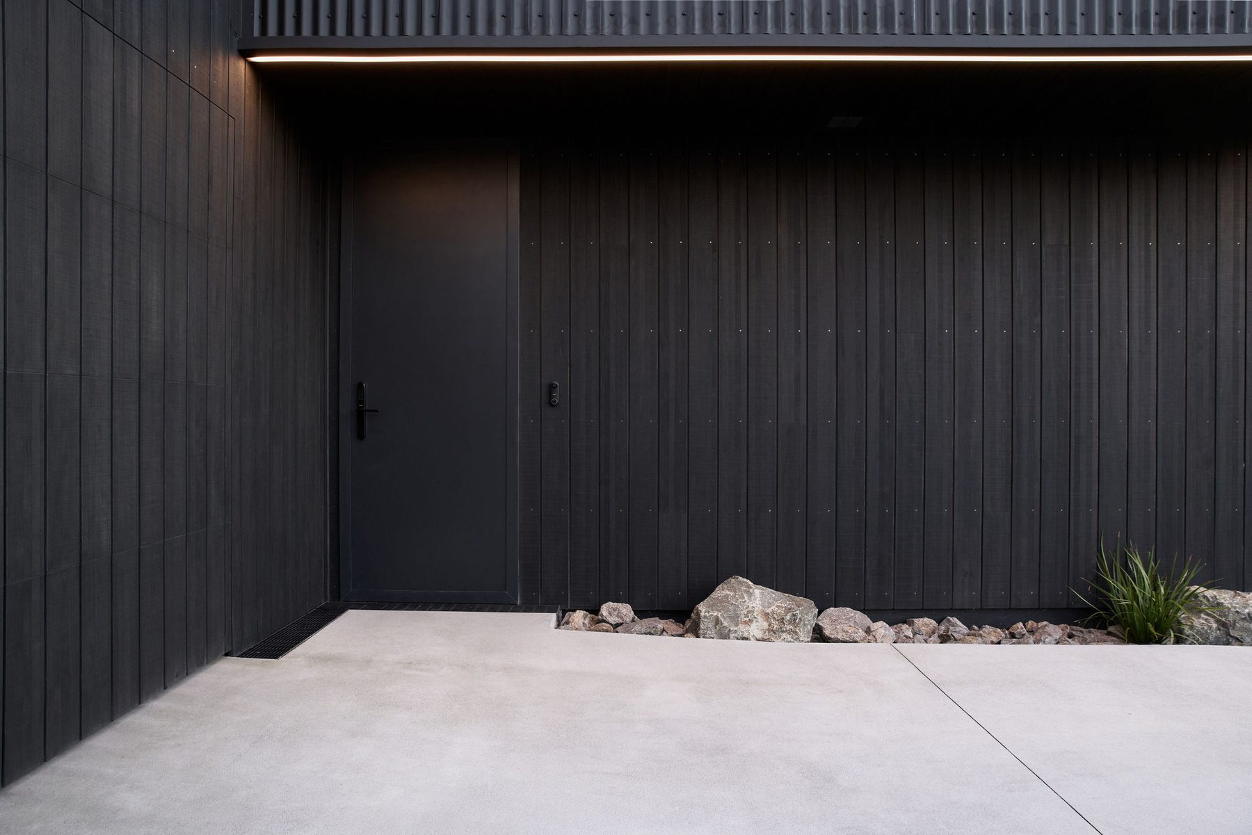 Kuroi Ma House: the entrance in dark timber and concrete.