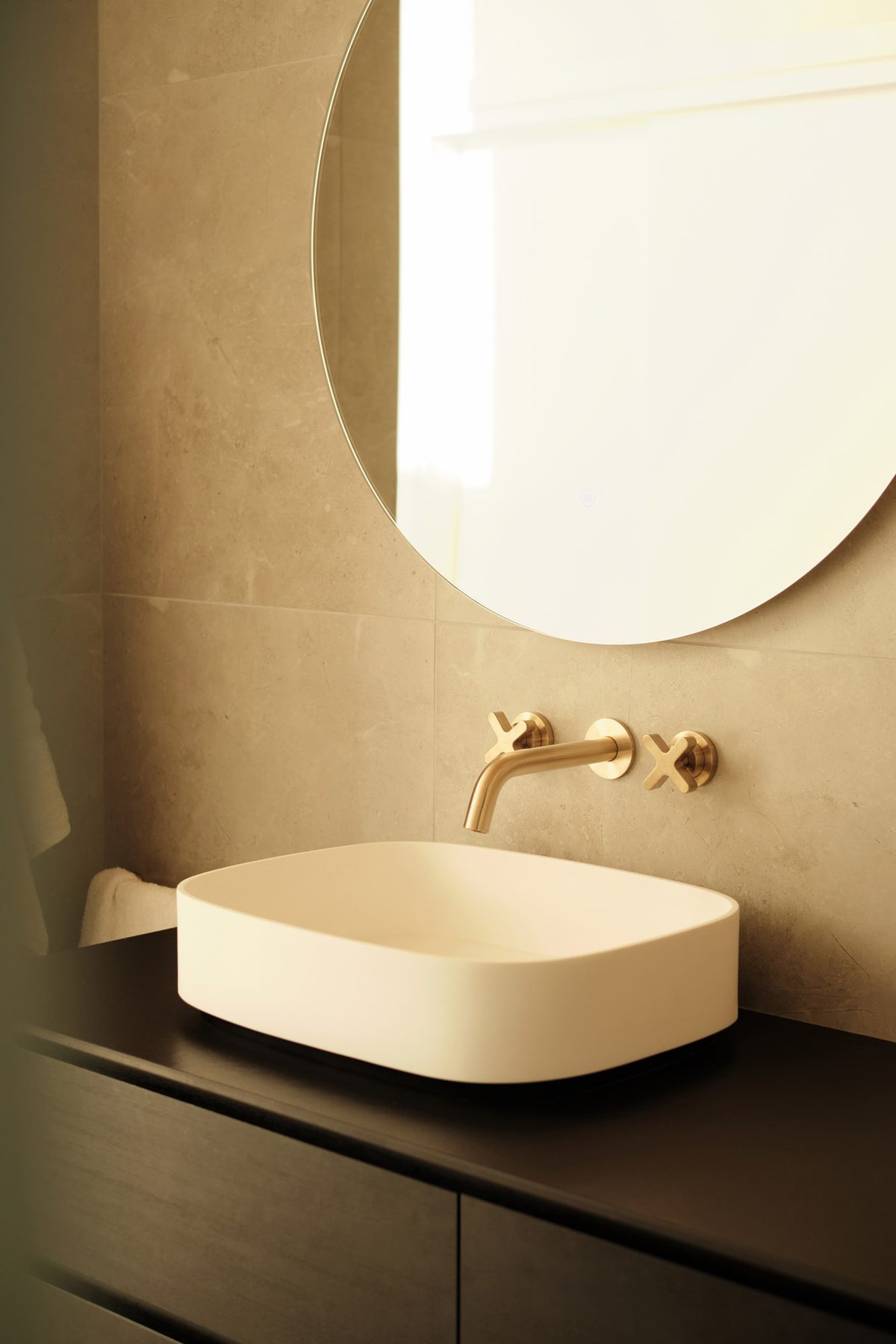 Bathroom basin in stone and brass.