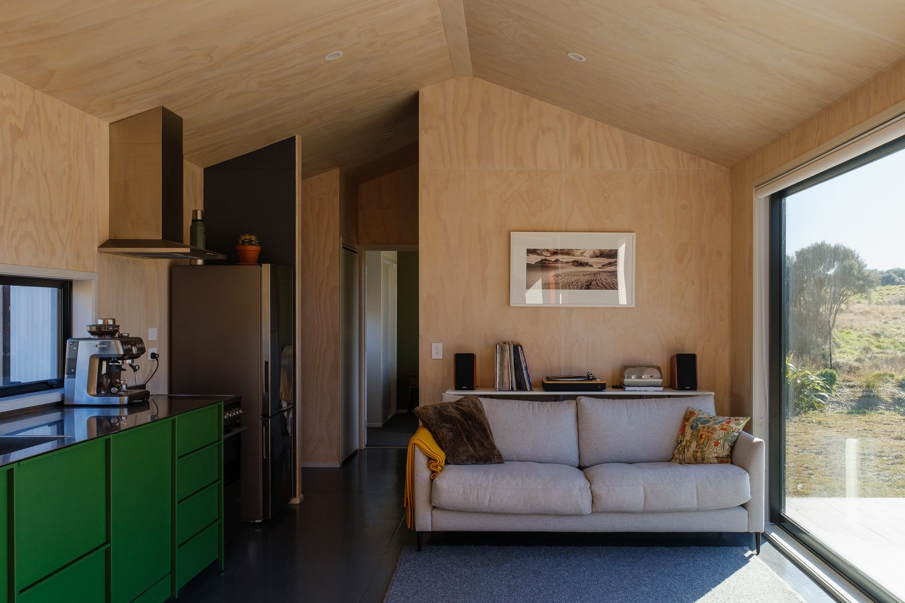 Open living under the apex ceiling, doors to the deck.