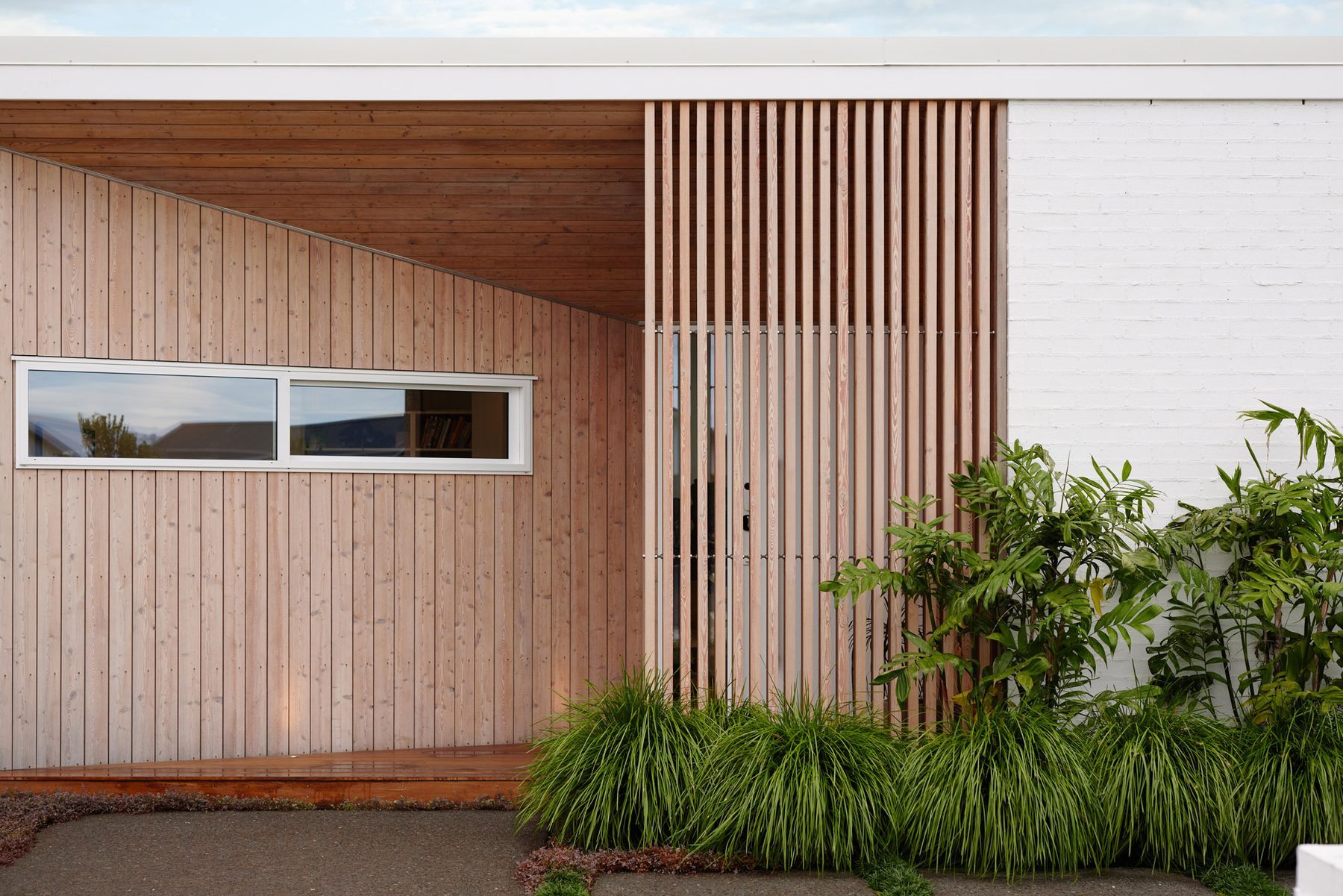 Warm timber entry recess against the white façade.